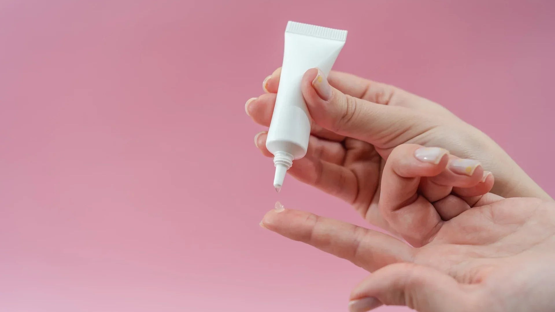 A person squeezing gel from a tube