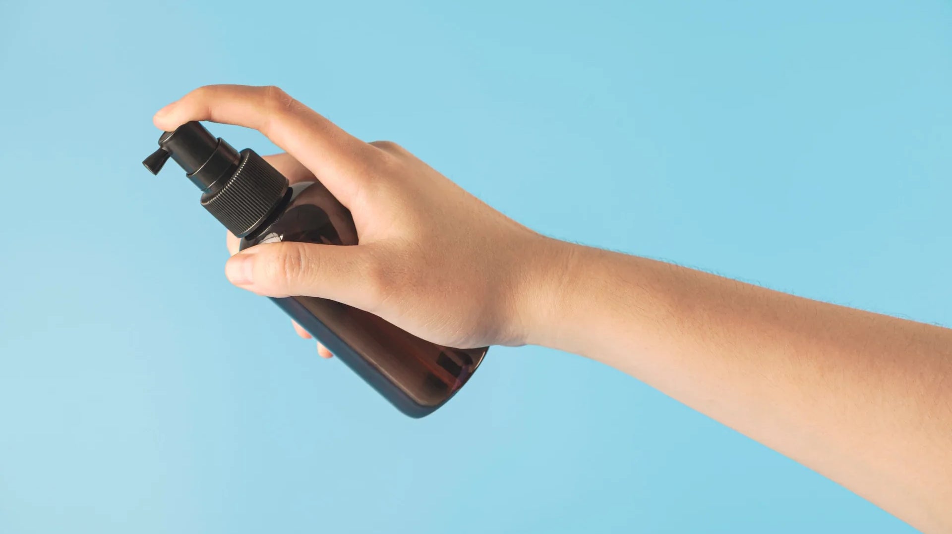 A person’s hand holding a bottle of gel