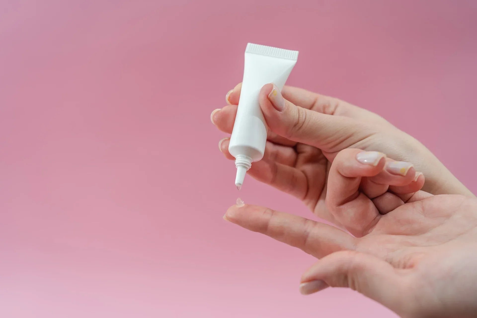 A person squeezing gel from a tube
