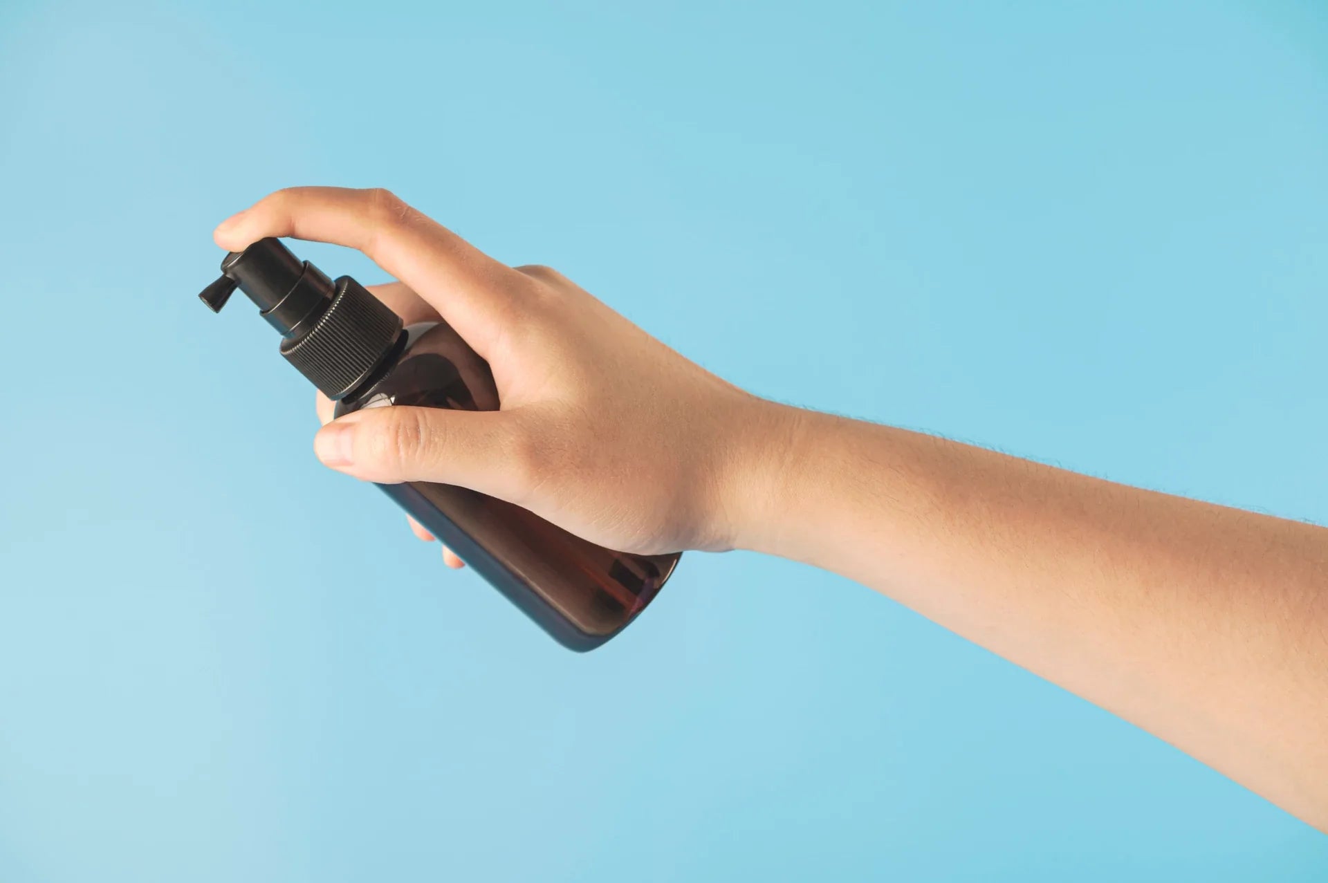 A person’s hand holding a bottle of gel